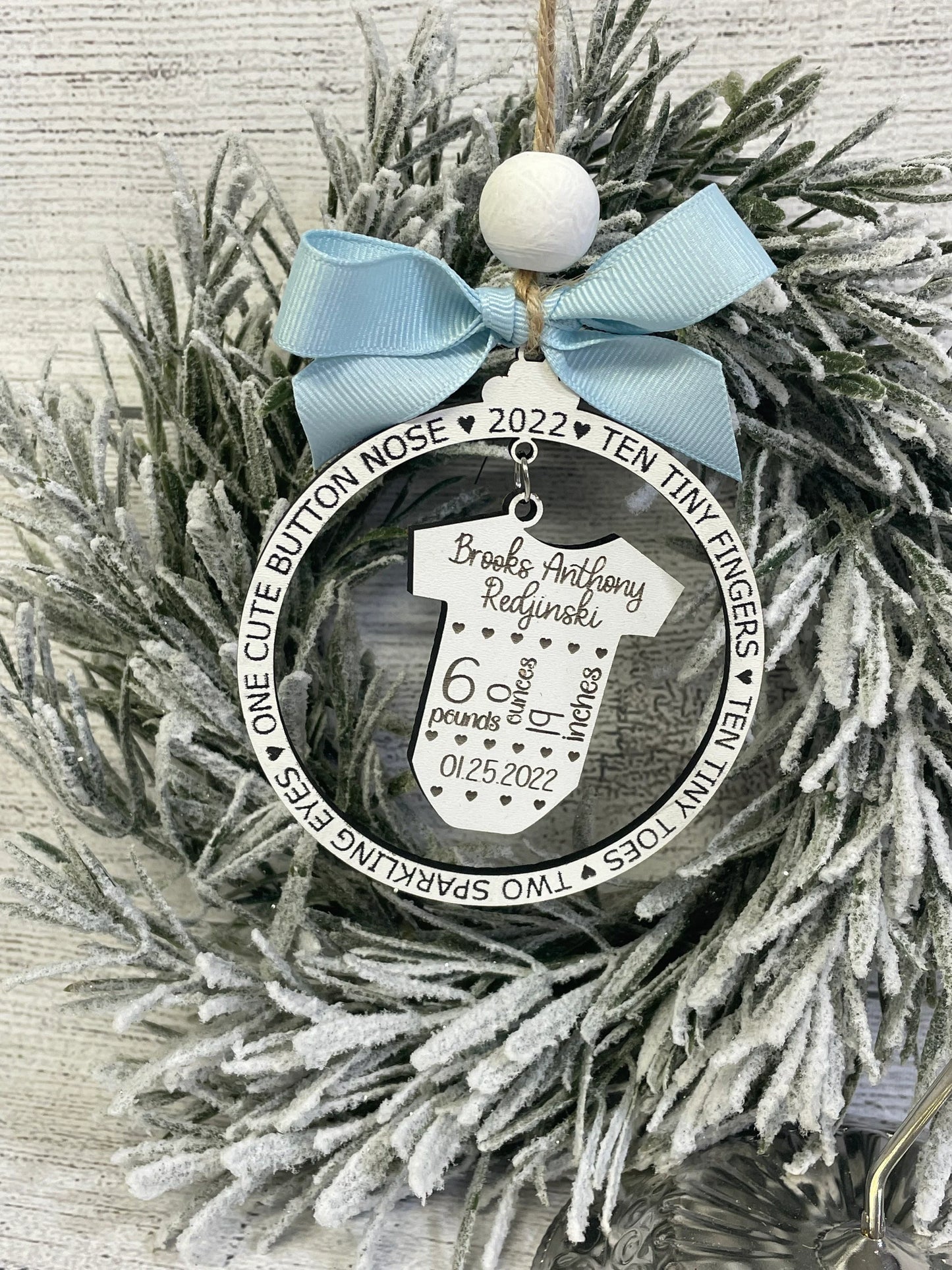 Baby’s first Christmas birth stat ornament hanging as holiday décor and nursery keepsake gift