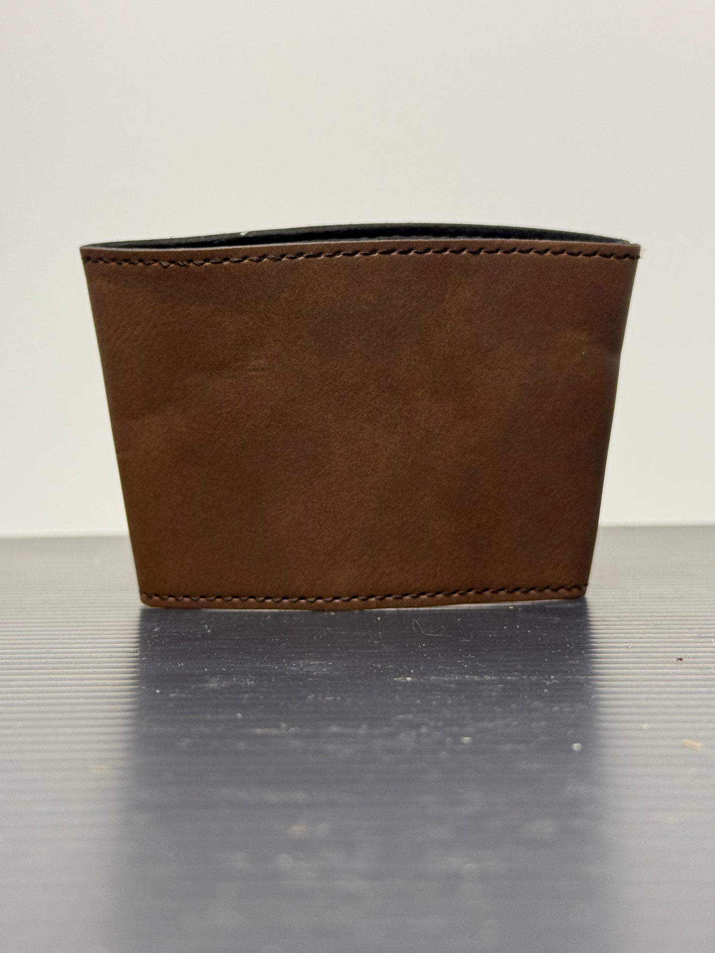 Laser engraved leatherette sleeve wrapped around a travel tumbler