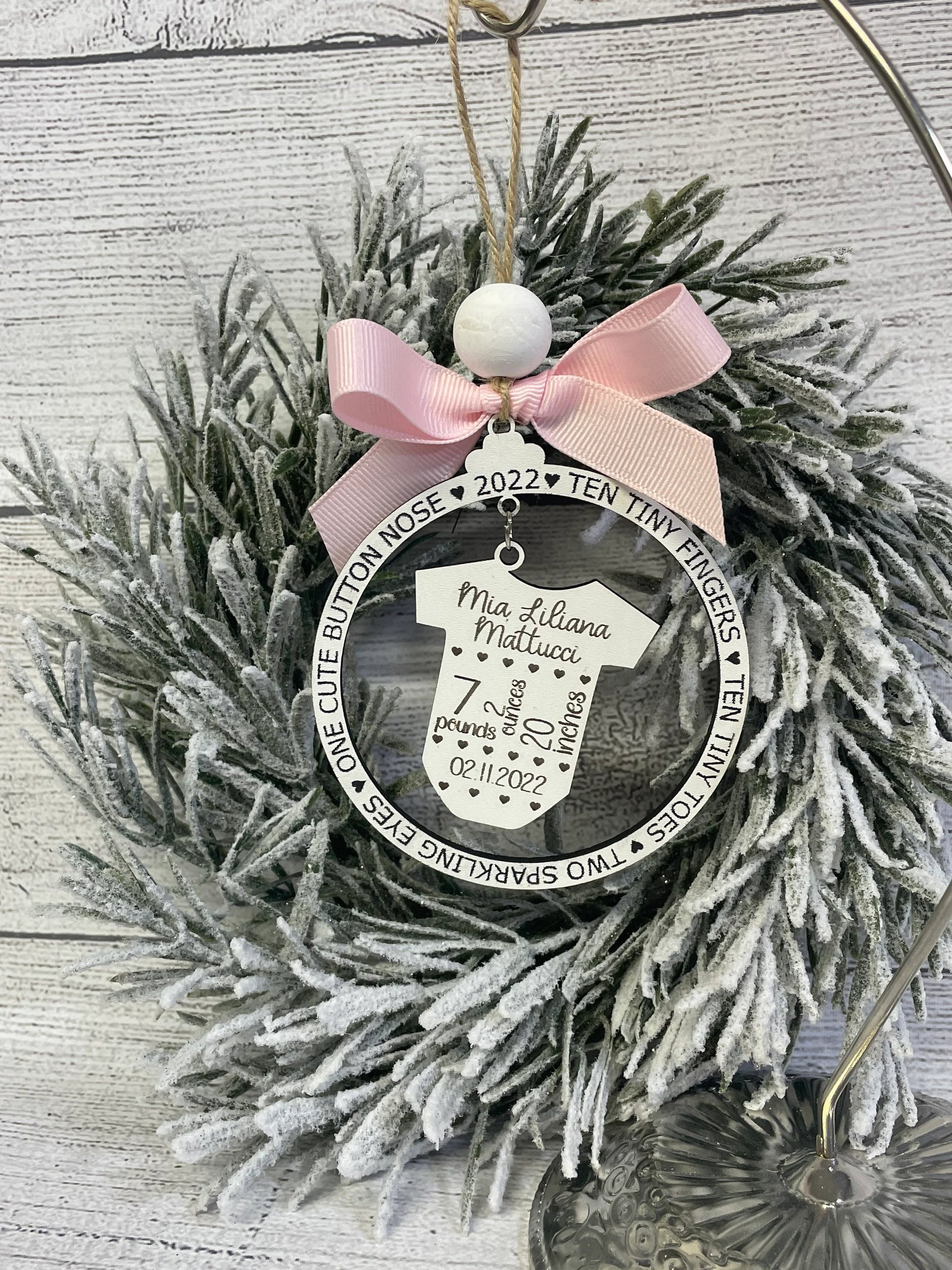 Close-up of engraved birth stat ornament showing newborn name, birth date, weight and length
