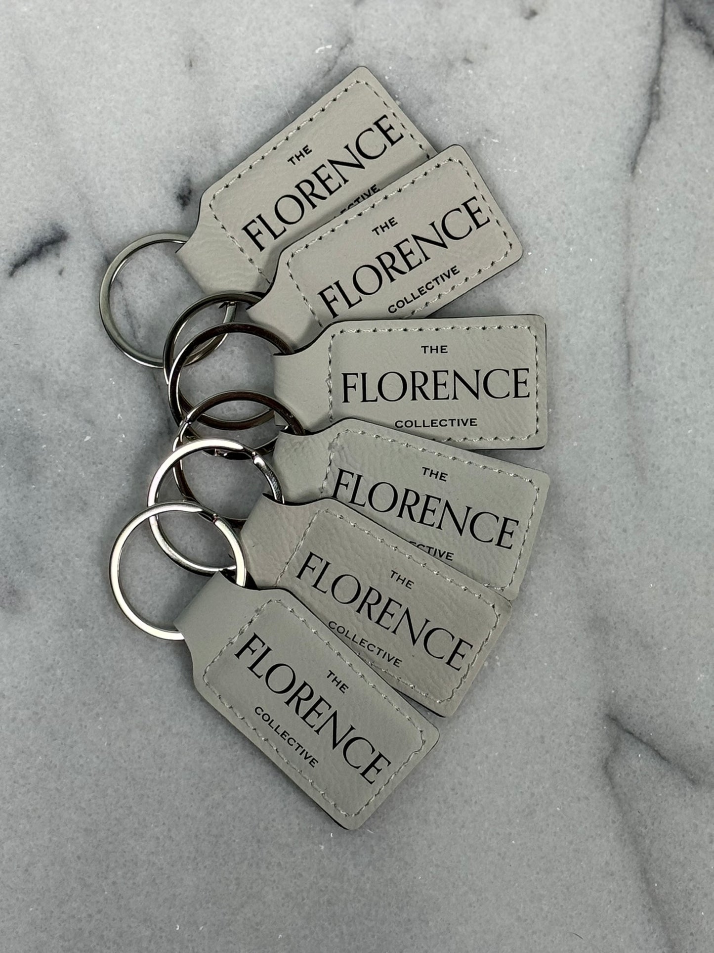 Close-up detail of black engraving on white leatherette keychain