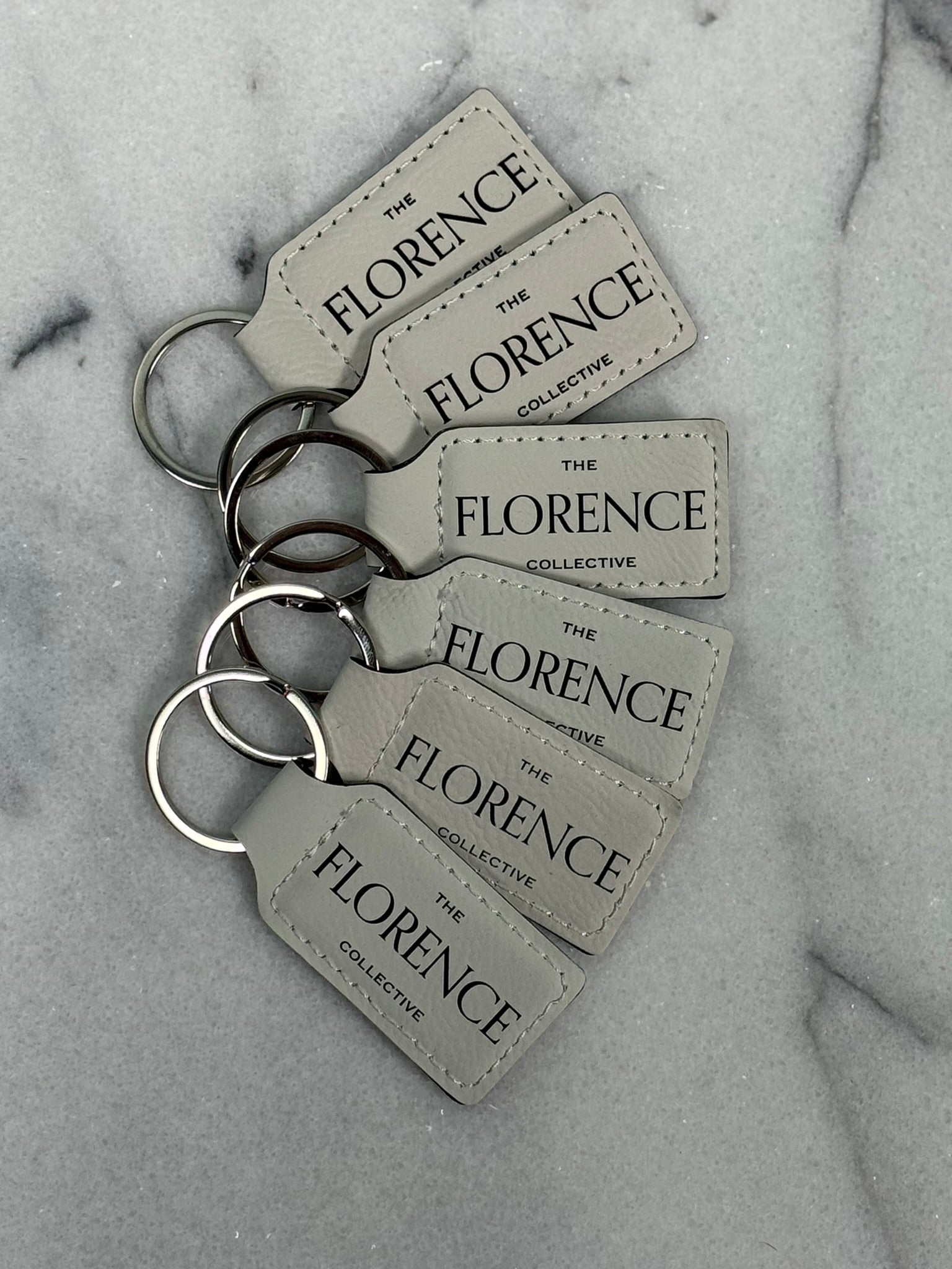 Close-up detail of black engraving on white leatherette keychain