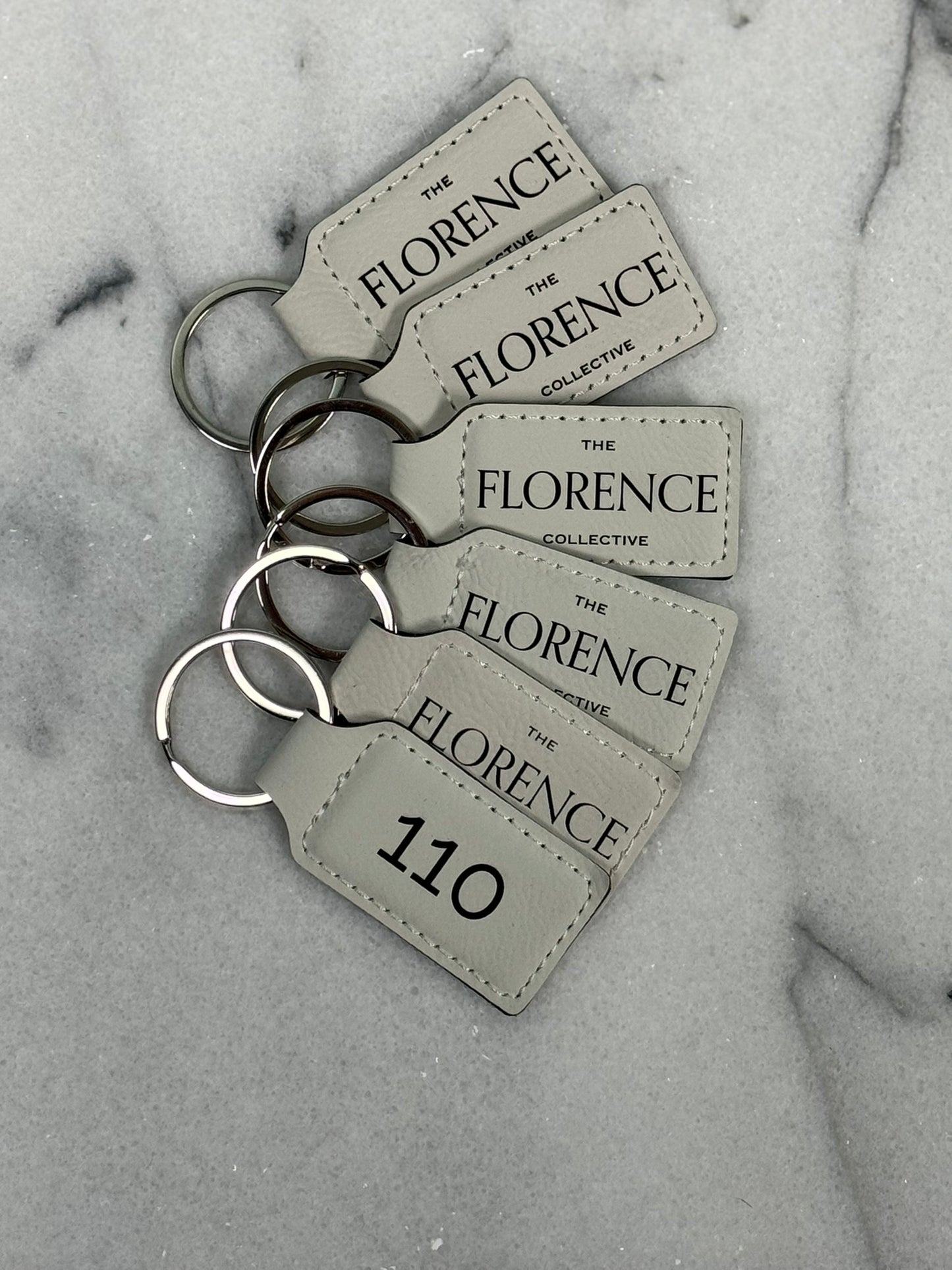 Front and back view of personalized leatherette rectangle keychain with custom engraving on both sides