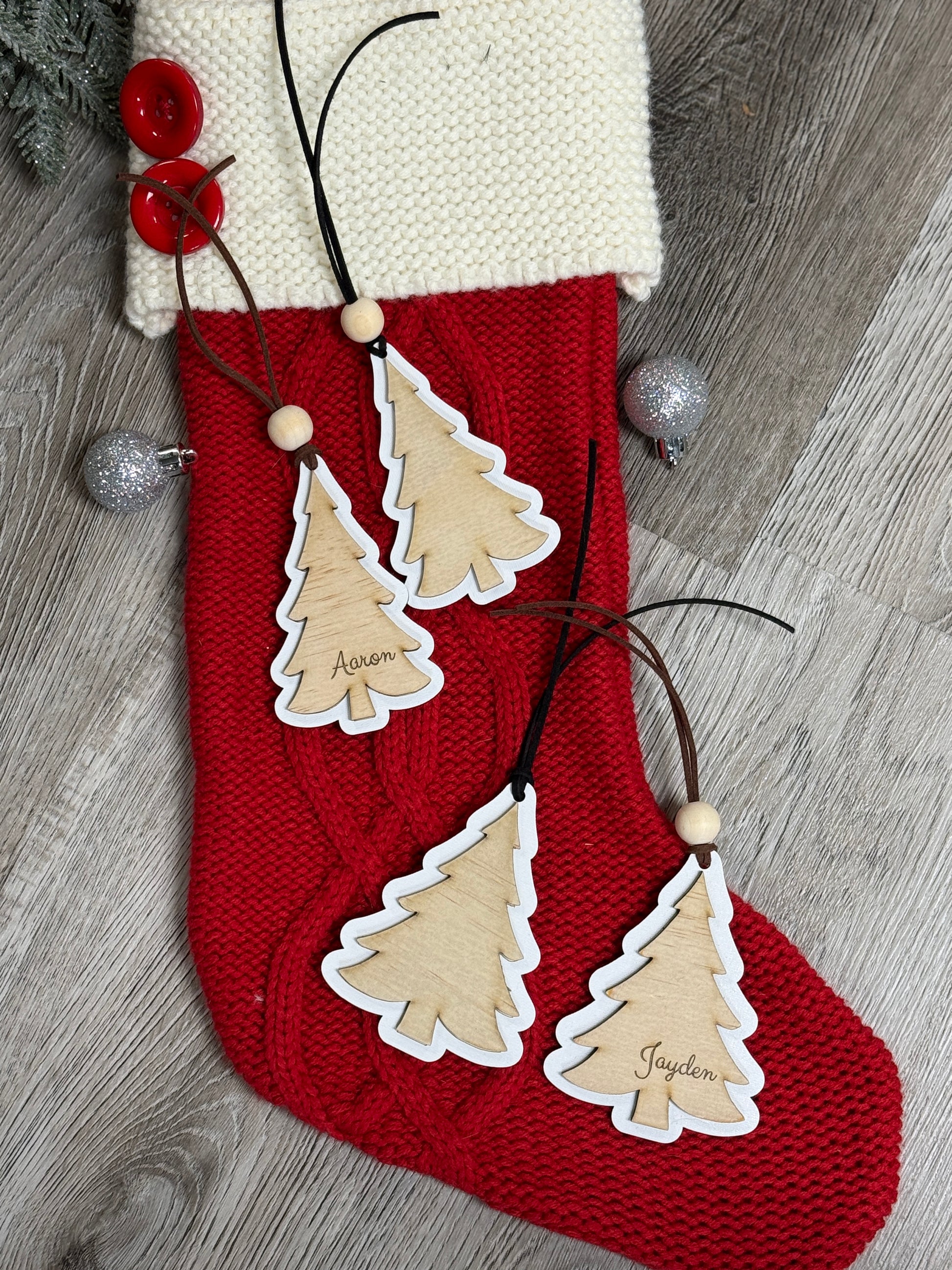 Close-up of a personalized wooden Christmas tree stocking tag with laser engraved name.