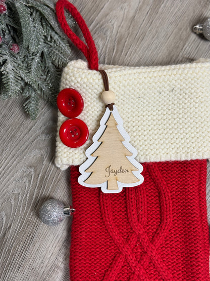 Close-up of a personalized wooden Christmas tree stocking tag with laser engraved name