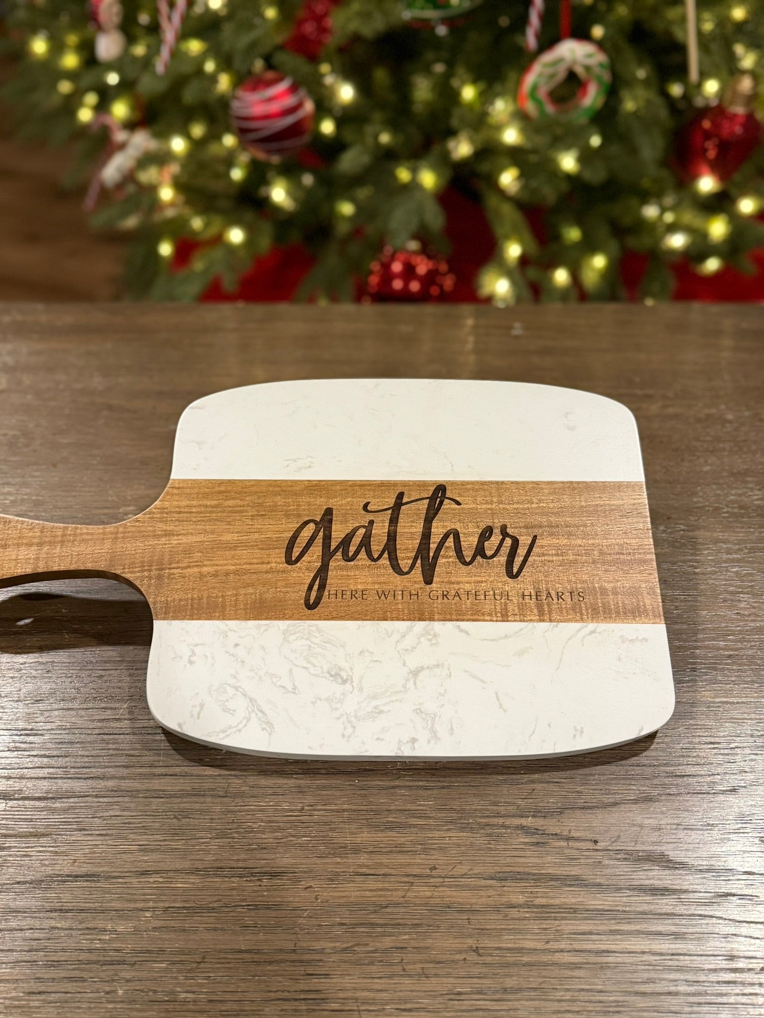 Close up of laser engraved family name on personalized acacia wood serving board