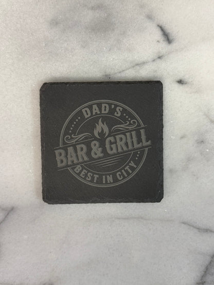 Close-up of hand-chiseled natural slate coaster with engraved business logo
