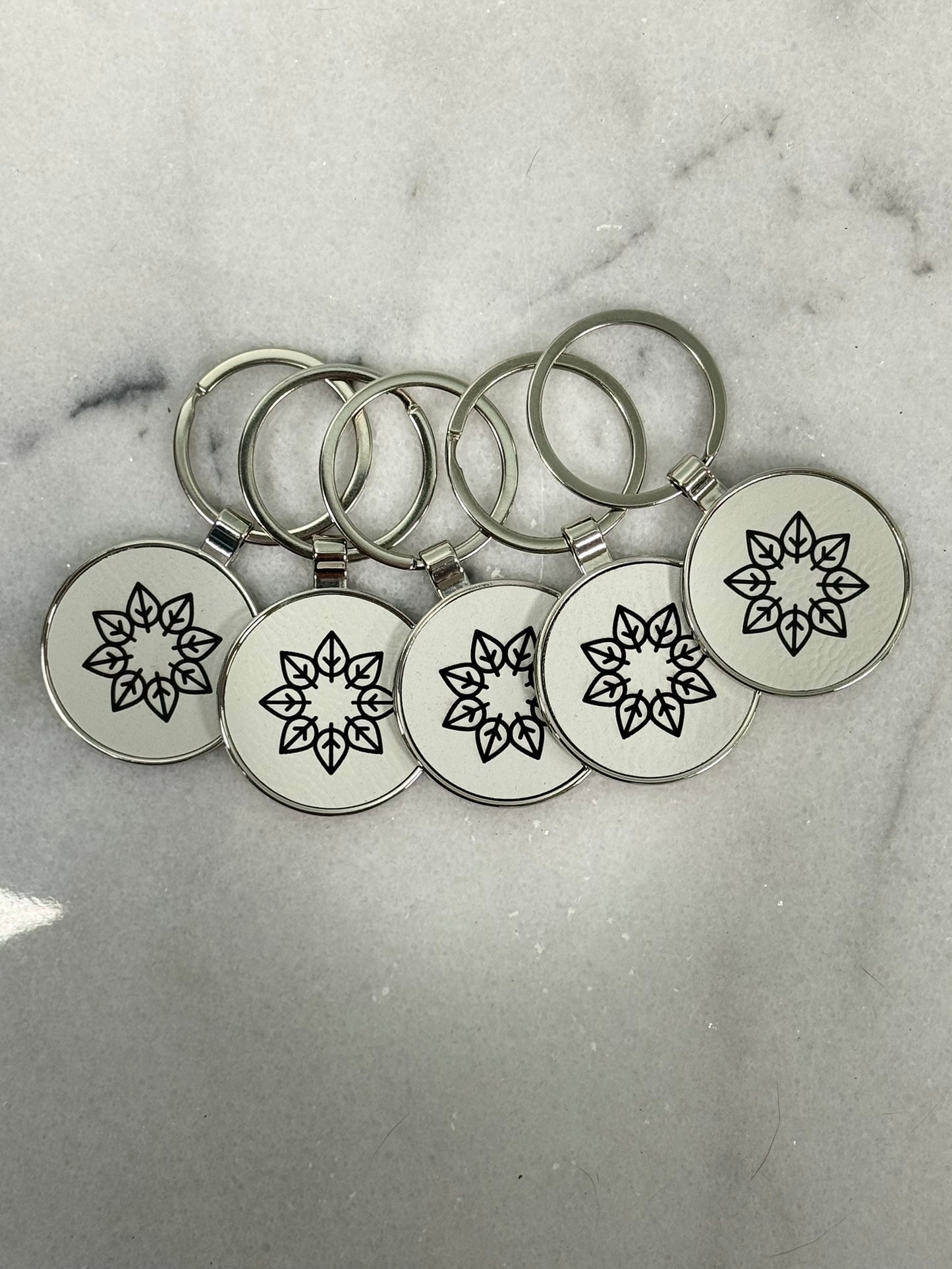 Close-up of laser engraved round metal keychain showing detailed custom engraving
