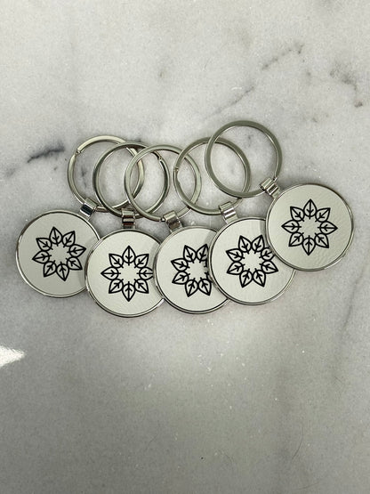 Close-up of laser engraved round metal keychain showing detailed custom engraving